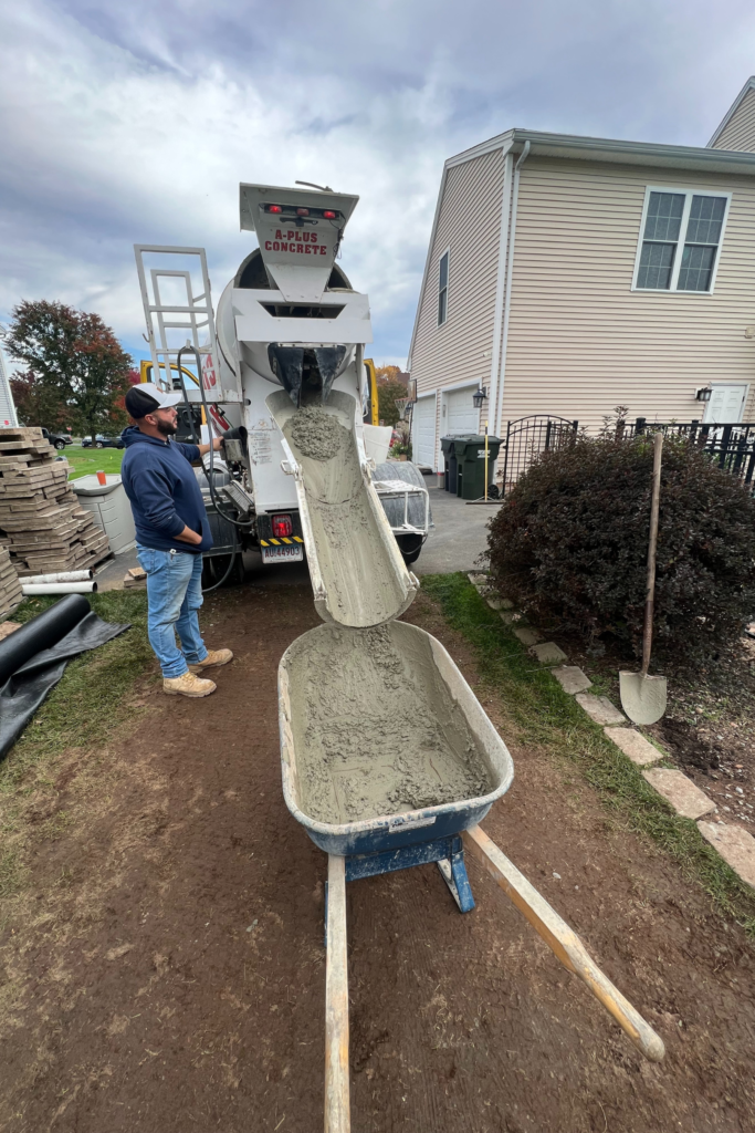 A Plus Concrete | Ready to Mix Concrete Delivery in Western CT | Man pouring concrete in backyard